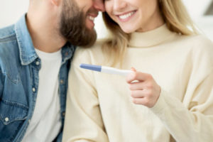 Woman and man together holding a pregnancy test